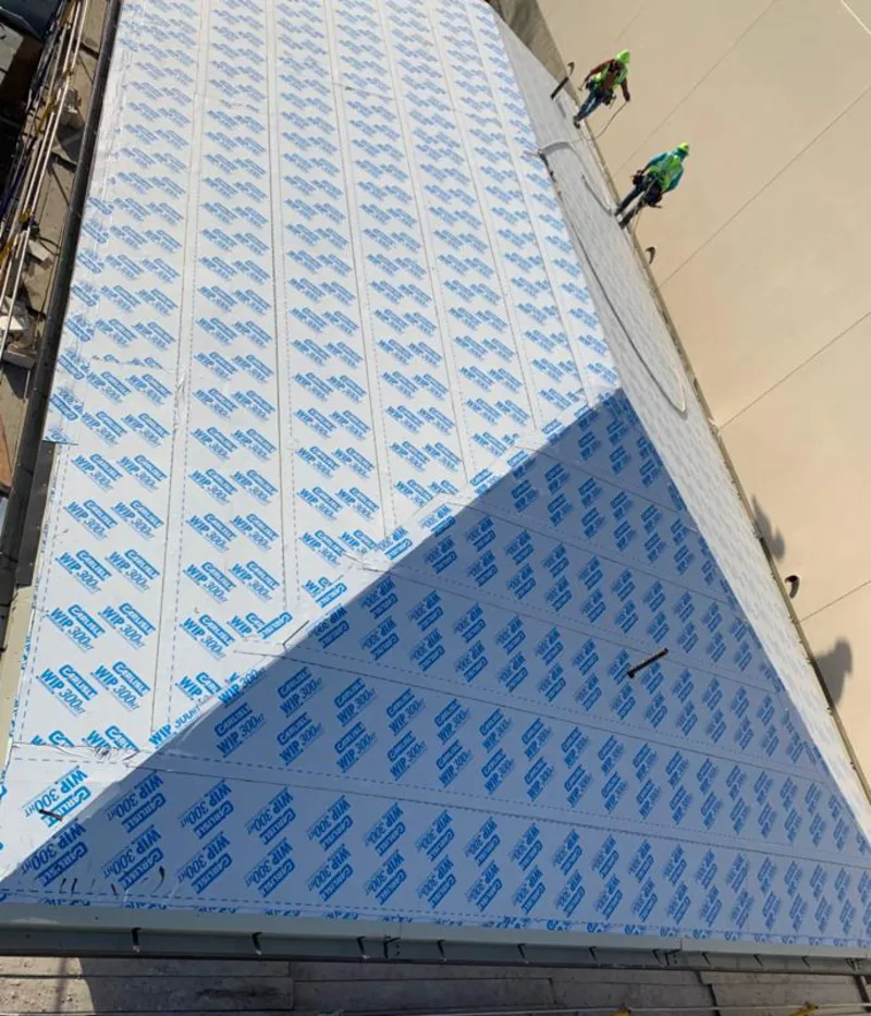 Professional roofers installing underlayment on a metal roof in St. Paul Park